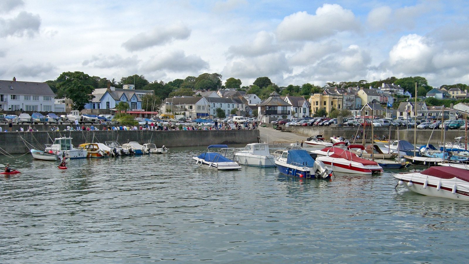 Boats moored in Saundersfoot harbour with the village along the waterfront